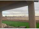 Covered patio overlooking a backyard with artificial turf and a wrought iron fence at 9394 Vital Crest St, Las Vegas, NV 89123