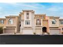 Exterior of three-story townhomes with varied neutral-tone paint, garage and balcony, offering curb appeal at 10091 Sand Key St, Las Vegas, NV 89178