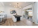 A modern dining room features an elegant light fixture and a view of the outdoor patio at 10809 Garden Mist Dr # 2072, Las Vegas, NV 89135