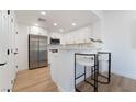 Bright kitchen features stainless steel appliances, white cabinets, and counter seating at 10809 Garden Mist Dr # 2072, Las Vegas, NV 89135