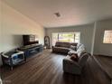 Bright living room with hardwood floors, a sectional sofa, and a large window offering natural light at 1104 Oak Tree Ln, Las Vegas, NV 89108