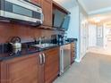 Modern kitchenette features stainless steel appliances, granite countertops, and dark wood cabinetry at 135 E Harmon Ave # 2104, Las Vegas, NV 89109