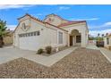 Close up of home with desert landscaping, red tile roof and an arched entryway at 15 Richland Acres Ct, Henderson, NV 89074