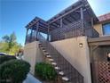 Low-angle view of home featuring an open-air patio on the second floor with stairs and a landscaped yard at 1847 Avacado Ct, Henderson, NV 89014