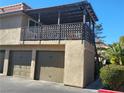 Exterior view of a two-story home featuring an open-air patio, garages, and desert landscaping at 1847 Avacado Ct, Henderson, NV 89014