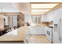 Bright kitchen with white cabinets, tiled countertops, and modern appliances, seamlessly blending style and functionality at 2042 Waverly Cir, Henderson, NV 89014