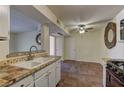View of kitchen sink and adjacent dining area with ceiling fan and tile flooring at 2120 Ramrod Ave # 415, Henderson, NV 89014