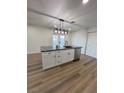 Kitchen island with gray countertop and stainless dishwasher complements modern white cabinetry at 2413 Valparaiso St, Las Vegas, NV 89108