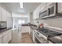 Well-lit kitchen with stainless steel appliances, black countertops, and white cabinets at 2609 Orchard Meadows Ave, Henderson, NV 89074