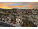 Aerial view of a desert community, showcasing the landscape, neighboring homes, and stunning sunset at 2920 Foxtail Creek Ave, Henderson, NV 89052