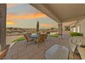 Covered patio with an outdoor dining table and chairs and a putting green at 2920 Foxtail Creek Ave, Henderson, NV 89052