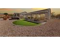 The backyard features a covered patio, a putting green, a hot tub, and well-maintained landscaping at 2920 Foxtail Creek Ave, Henderson, NV 89052