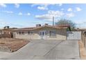 Cozy single-story home featuring a red tile roof, secure window bars, and a spacious concrete driveway at 2963 Greendale St, Las Vegas, NV 89121