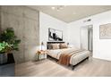 Serene bedroom featuring a platform bed, concrete accent wall, and neutral decor at 353 E Bonneville Ave # 311, Las Vegas, NV 89101