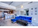 Open-concept living room with a blue velvet sofa, breakfast bar, and hardwood floors at 353 E Bonneville Ave # 905, Las Vegas, NV 89101