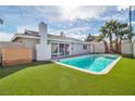 Backyard pool with artificial grass and privacy fence offers a refreshing outdoor oasis at 4500 Charles Ronald Ave, Las Vegas, NV 89121