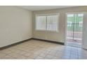 A sunlit living room with neutral walls, tiled flooring, and an exit door at 520 S 13Th St # D17, Las Vegas, NV 89101