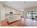 Open concept kitchen with granite countertops, stainless appliances, and hardwood flooring at 580 Kenerly St, Henderson, NV 89015