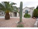 View of the house from the front yard with desert landscaping, cacti, and shrubbery at 7233 Alsop Ct, Las Vegas, NV 89156