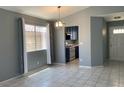 Open-concept dining area with view to the kitchen, light fixture, and natural lighting at 7728 Barbican Ct, Las Vegas, NV 89147