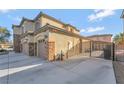 Side view of a three-car garage home, with a gated driveway and stone accents at 7778 Villa Montara St, Las Vegas, NV 89123