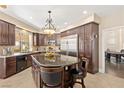 Well-equipped kitchen boasts dark wood cabinetry, granite countertops, and stainless-steel appliances at 9517 Spanish Steps Ln, Las Vegas, NV 89117