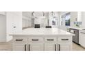 Modern white kitchen featuring a large island with white marble countertop and stainless steel appliances at 9795 La Cienega St, Las Vegas, NV 89183