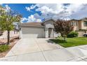 A single-story home shows off its simple desert landscaping, a driveway, and a two-car garage at 10976 Salernes St, Las Vegas, NV 89141