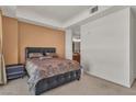 Cozy bedroom with a padded headboard, side table, tan walls, and an adjacent bathroom at 2405 W Serene Ave # 817, Las Vegas, NV 89123