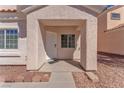 Covered front porch and entry featuring textured walls, desert landscaping, and charming curb appeal at 2420 Belt Buckley Dr, Henderson, NV 89002