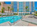Exterior view of a pool with tall condominiums in the background, palm trees and lounge chairs at 2700 Las Vegas Blvd # 910, Las Vegas, NV 89109