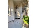 Front door with a decorative wreath and a welcoming mat, enhanced by lush greenery and charming accents at 4534 Regalo Bello St, Las Vegas, NV 89135