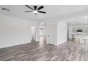 Open-concept living room with wood-look tile flooring flowing into the kitchen and dining areas at 4905 Madre Maria Ct, North Las Vegas, NV 89031