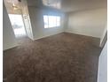 Neutral living room with carpet, large window, and glass paneled front door at 5129 Sugarfoot Ave, Las Vegas, NV 89107