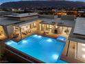 A sparkling pool and hot tub are the focal point of the outdoor living space at twilight at 63 Midnight Sky Dr, Las Vegas, NV 89135