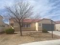 Attractive single-story home with a well-maintained front yard, gray garage door and desert landscaping at 6615 Montezuma Castle Ln, North Las Vegas, NV 89084