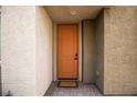 Inviting front entryway with a vibrant orange door and a 'Welcome' mat at 6925 Cuddy Falls Pl, North Las Vegas, NV 89084