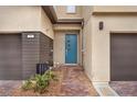 Home entrance features brick pavers leading to a modern teal front door with sidelights and a storm door at 752 Echelon St, Las Vegas, NV 89138