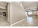 Bright foyer with tile flooring, staircase, and doorway to an office space with built-in desk at 8173 Dusky Shadows St, Las Vegas, NV 89113