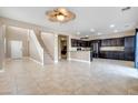 Expansive living space with tile floors and views of the open kitchen and staircase to the second level at 8173 Dusky Shadows St, Las Vegas, NV 89113