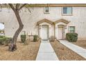 Townhouse exterior featuring a sidewalk leading to two front doors at 8787 Roping Rodeo Ave # 101, Las Vegas, NV 89178
