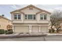 Two-story stucco townhouse with three garages and well-maintained landscaping at 8787 Roping Rodeo Ave # 101, Las Vegas, NV 89178