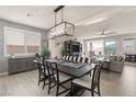 Elegant dining area with a modern chandelier, large windows, and seamless flow to the living area at 896 Janefield St, Las Vegas, NV 89148