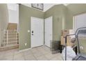 Tile foyer featuring a staircase with white railings, two white doors, and neutral paint at 9349 Lakefront Color St, Las Vegas, NV 89178