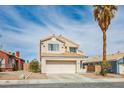 Two-story home featuring a two-car garage, desert landscaping and a beige stucco exterior at 938 Carnival Ave, Las Vegas, NV 89123