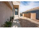 Beige stucco home with a landscaped walkway and view of the rear neighbor's roof at 938 Carnival Ave, Las Vegas, NV 89123