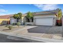 Lovely single-story home with a three-car garage, desert landscaping, and a concrete driveway at 9485 Parkmoor Ave, Las Vegas, NV 89149