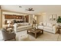 Spacious living room with plush sofas, a ceiling fan, and seamless flow to the kitchen at 1004 Bluebird Ridge Ct, North Las Vegas, NV 89084