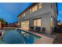 A tranquil pool reflecting the home's exterior with an attached spa, set against a twilight sky at 1004 Bluebird Ridge Ct, North Las Vegas, NV 89084