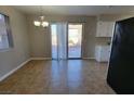 Bright dining area with a sliding glass door to backyard and a modern lighting fixture at 1016 Vantage Point Rd, Las Vegas, NV 89128